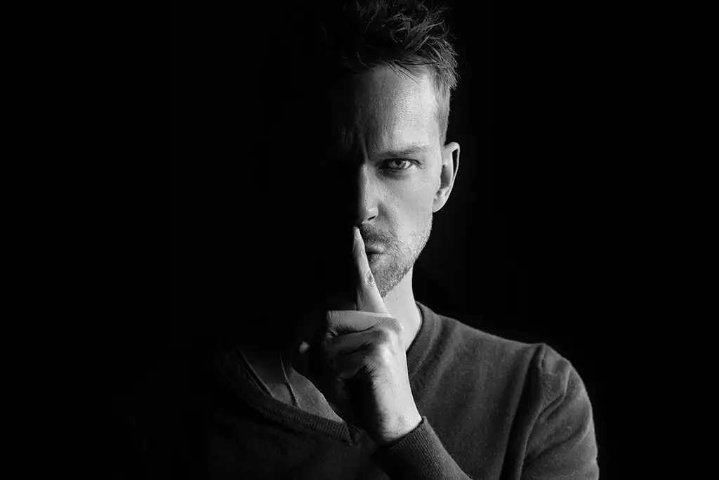 un hombre con el dedo en la boca